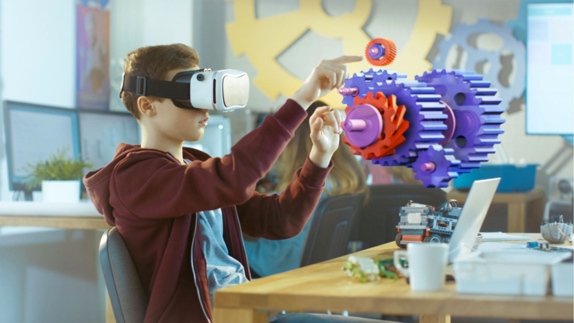 Ein Kind spielt mit einer futuristischen Maschine aus Zahnrädern und trägt eine Virtual Reality Brille.