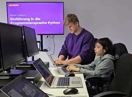 Einer unserer Lehrer lehrt einem Kind das Programmieren.